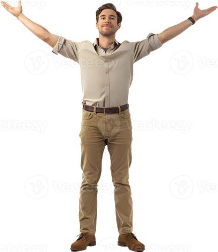 a man standing on the edge of a swimming pool with his hands in his pockets